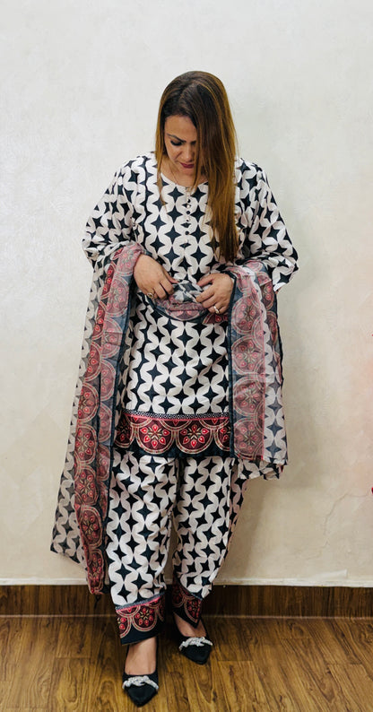 Close view of black and white geometric printed suit with red bordered dupatta detailing, SS-1008